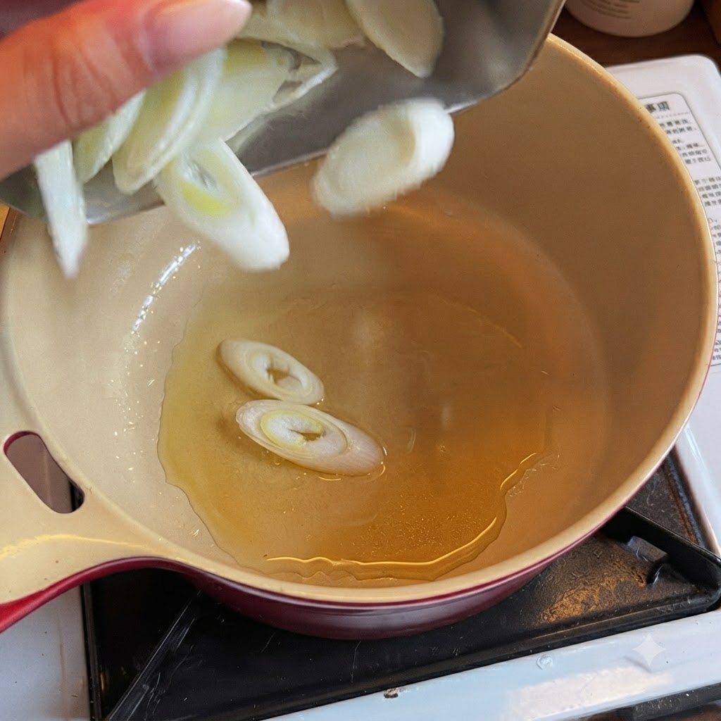 Des jeunes oignons émincés tombant dans une marmite remplie dhuile de cuisson.
