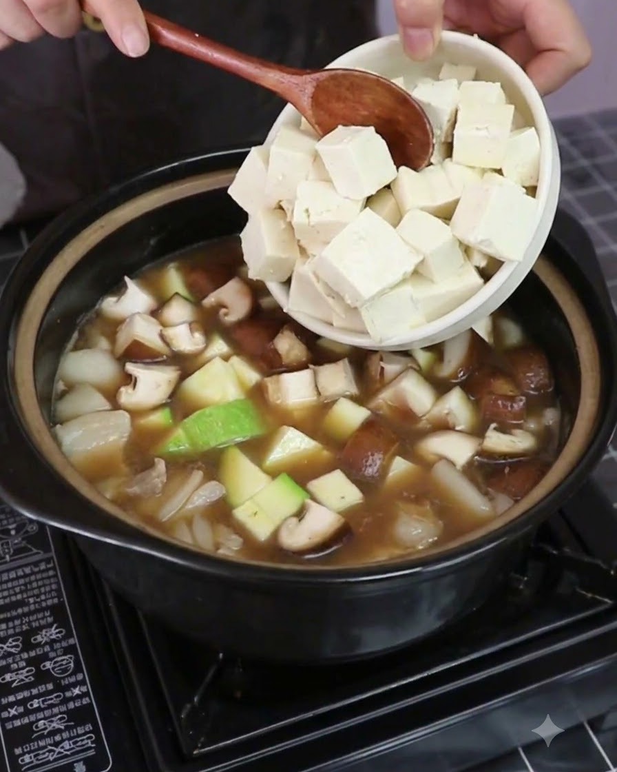 Cubes de tofu ferme ajoutés dans la casserole avec les légumes et le bouillon.