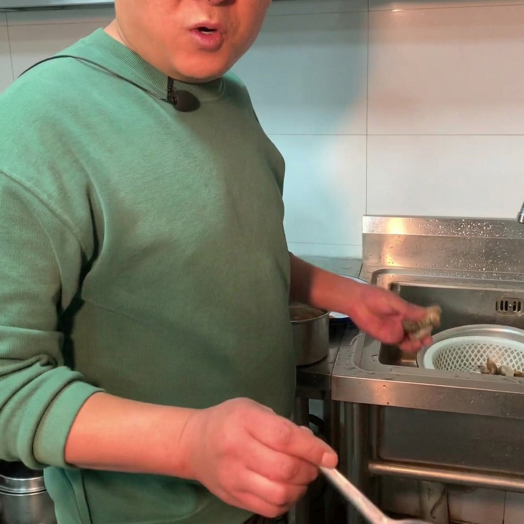 Des palourdes fraîches ajoutées dans une casserole de ragoût de pâte de soja frémissant.