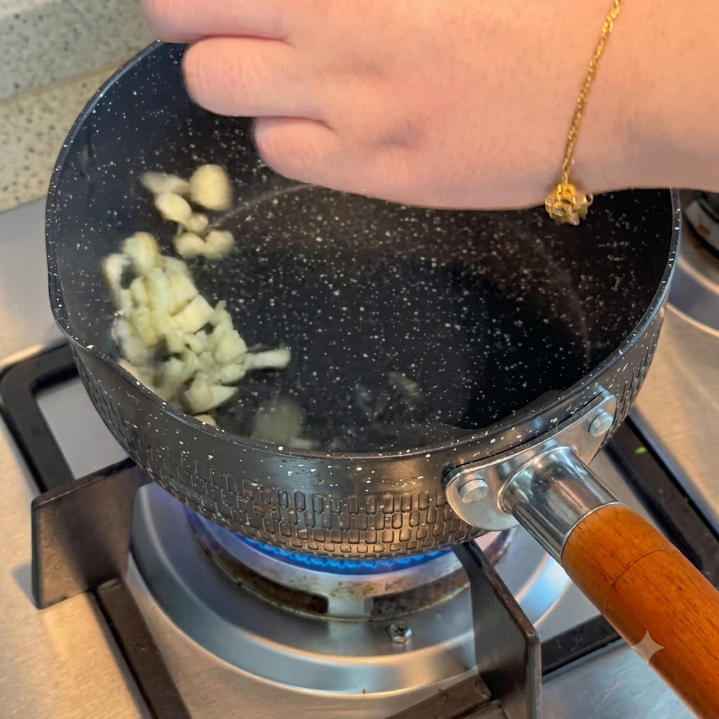 Ail émincé grésillant dans de lhuile chaude à lintérieur dune casserole sur un brûleur à gaz.