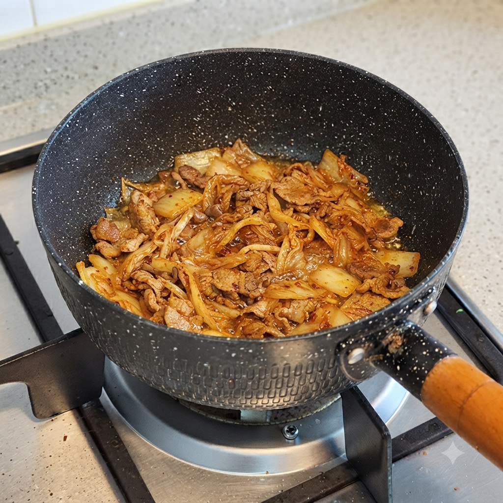 De leau versée dans une casserole contenant le kimchi cuit et le bœuf.