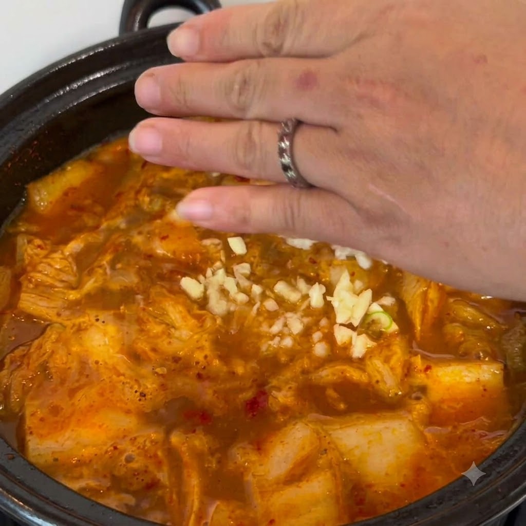 De lail émincé saupoudré à la main dans la casserole de ragoût bouillonnante.