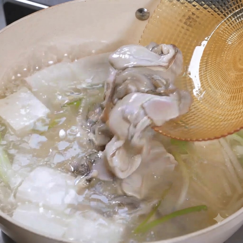 De la chair dhuître crue glissant dune écumoire dans une casserole bouillante de soupe au tofu.