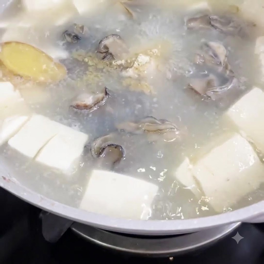 Du poivre blanc en poudre saupoudré dans une casserole de soupe bouillante avec des cubes de tofu et des huîtres.
