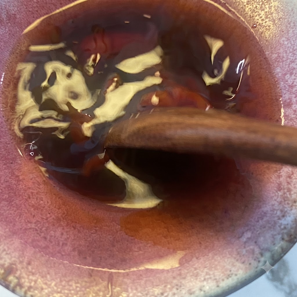 Le mélange de sauce teriyaki remué avec une cuillère en bois dans le bol.