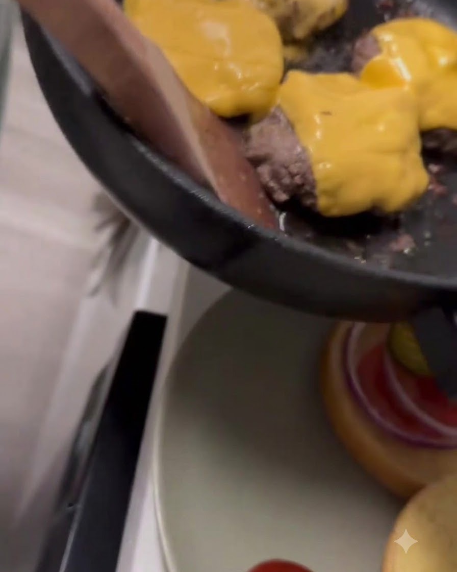 Du fromage cheddar jaune qui fond sur des steaks de bœuf à lintérieur dune poêle.
