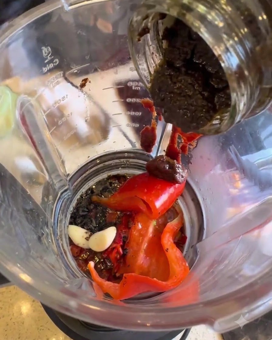 Pâte de truffe noire prélevée dun pot et ajoutée dans le mixeur.