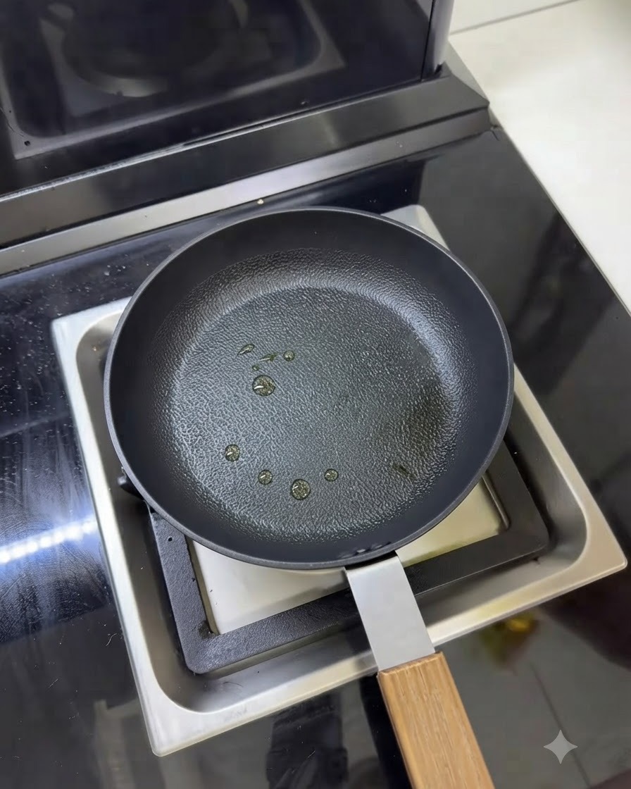Une poêle avec plusieurs petites gouttes dhuile de cuisson vaporisées à la surface.