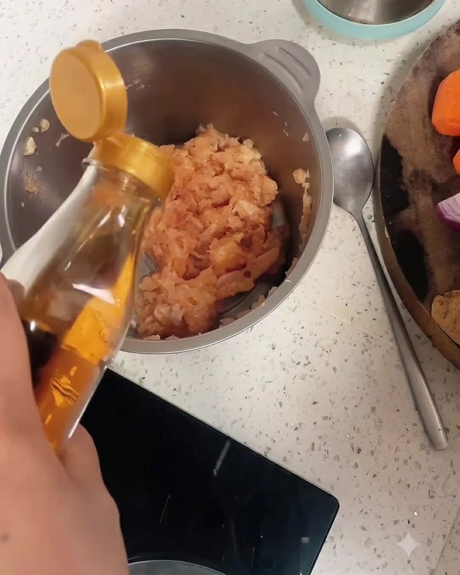 Vin de cuisine versé dune bouteille dans un bol en acier inoxydable rempli de poulet haché et de poivre.
