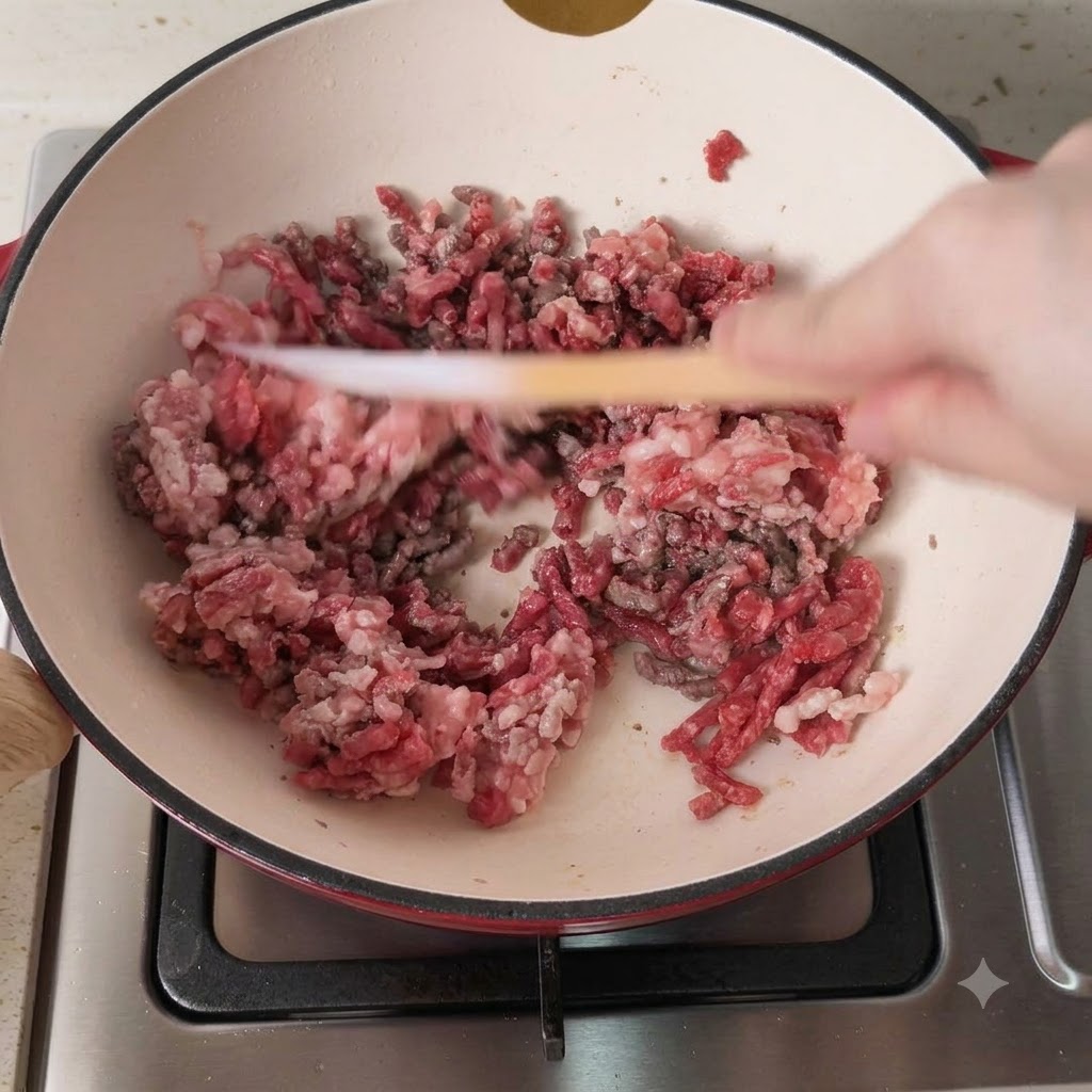 Mélange de porc et de bœuf hachés en train de dorer dans une casserole chaude.