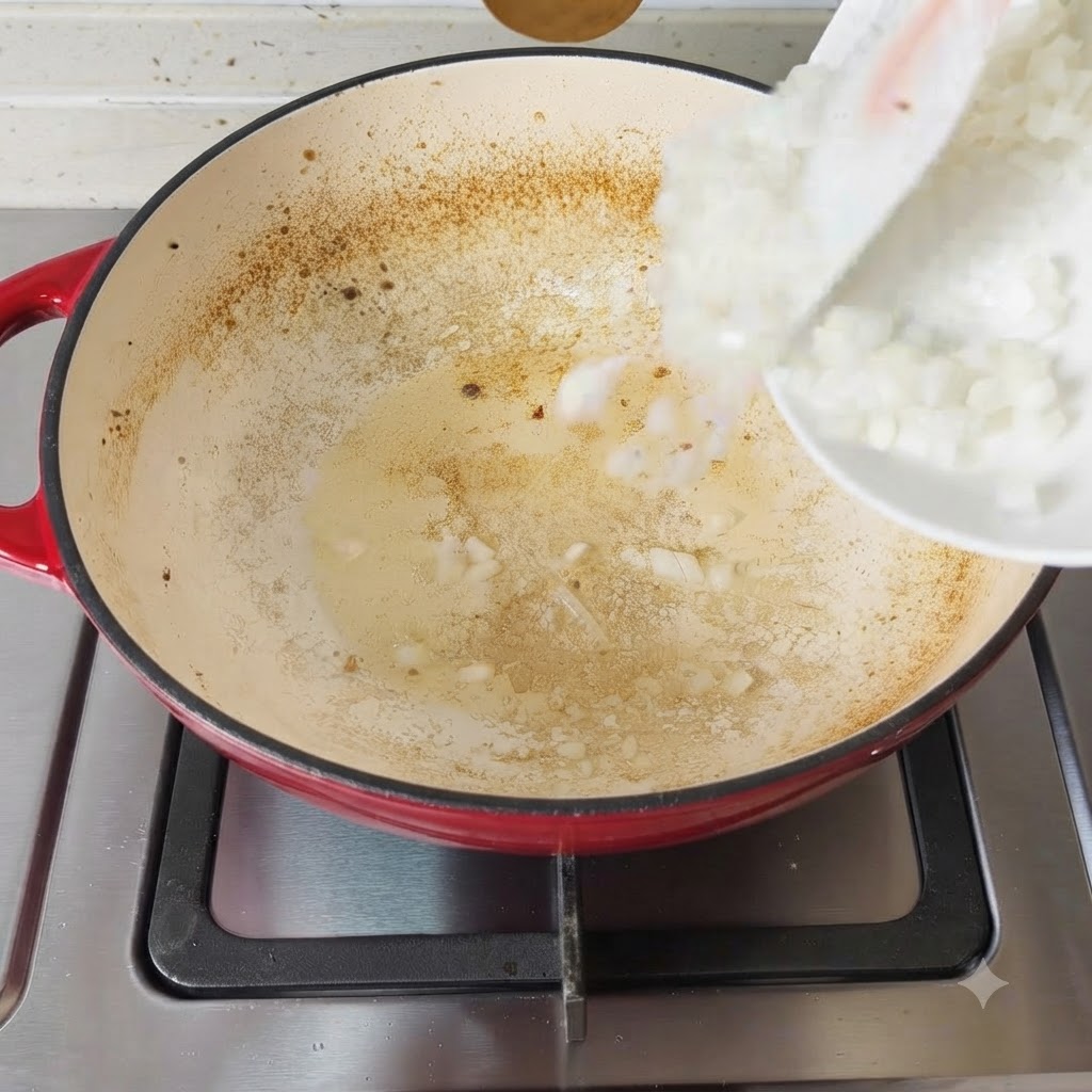 Oignons hachés touchant la surface chaude et assaisonnée de la poêle.