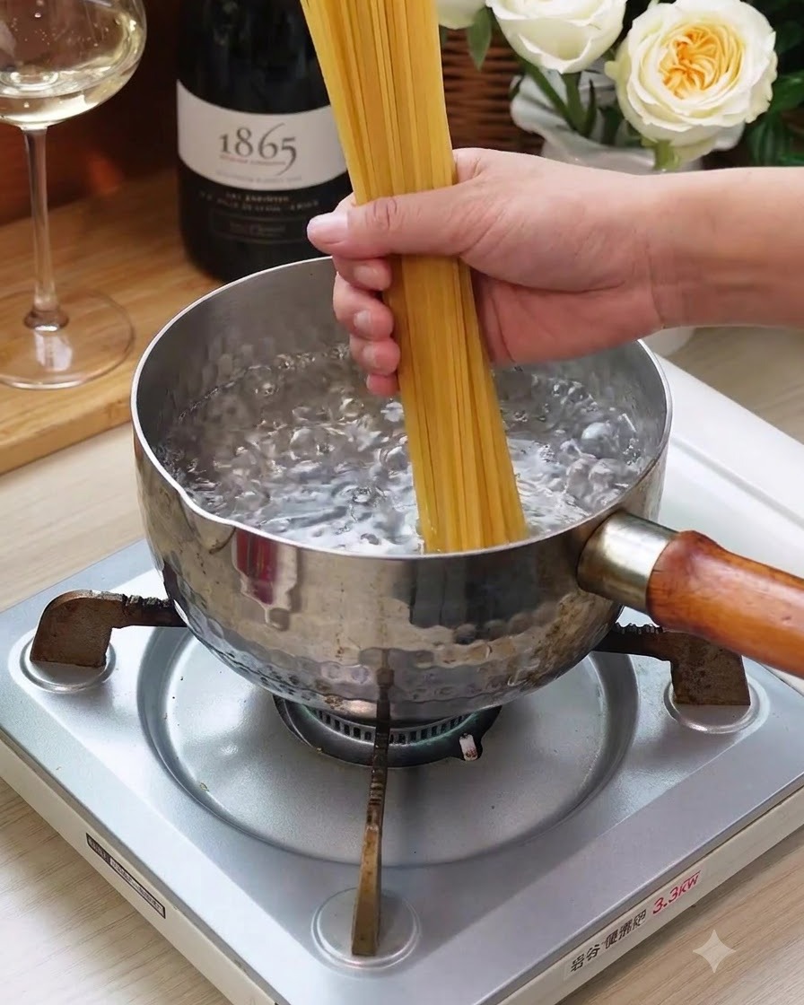 Une botte de nouilles spaghetti sèches plongée dans une casserole deau bouillante sur une cuisinière.