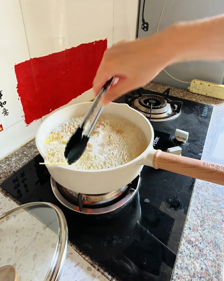 Pinces remuant des pâtes dans une casserole deau bouillante sur le feu.