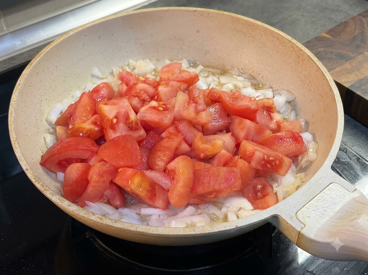 Ketchup ajouté à la poêle avec les tomates et les oignons.