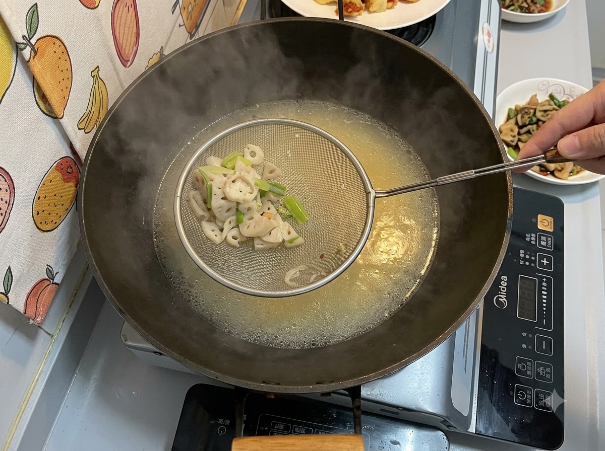 Une écumoire en métal tenant des morceaux solides filtrés au-dessus dun wok rempli dun bouillon crémeux jaunâtre mijotant.