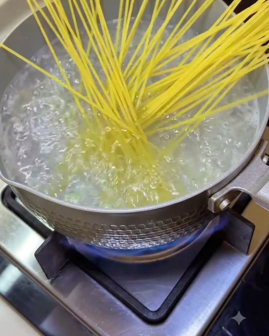Des nouilles spaghetti plongées dans une casserole deau bouillante frémissante sur la cuisinière.