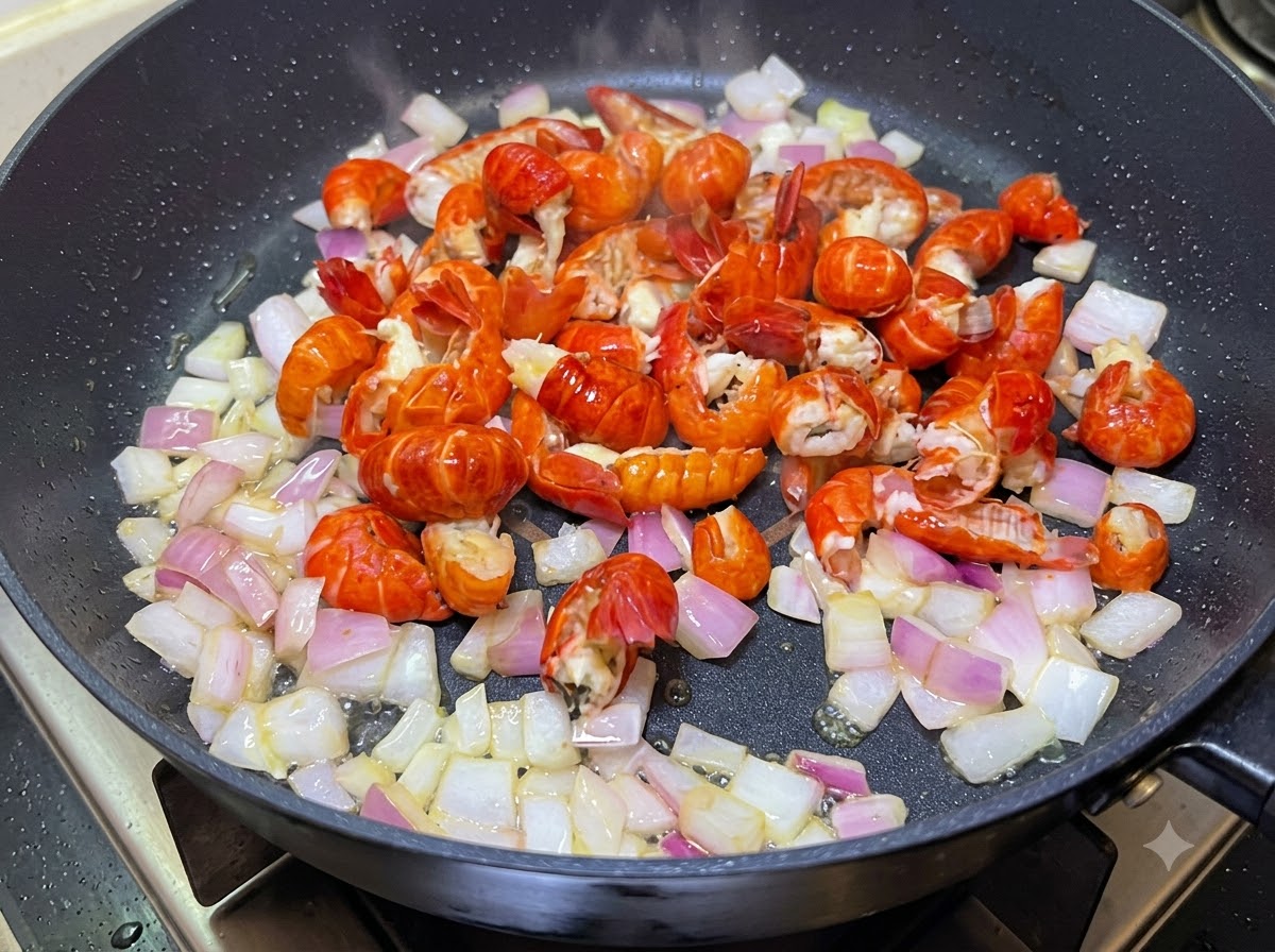 Des queues décrevisses et des oignons en dés cuisant ensemble dans une poêle.