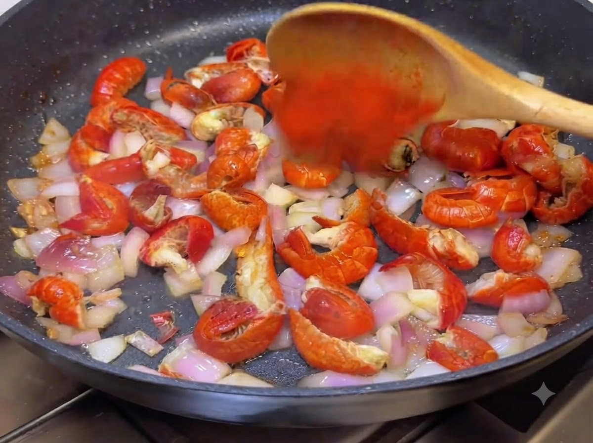 Du piment en poudre et de la sauce piquante coréenne mélangés dans la poêle avec une cuillère en bois.