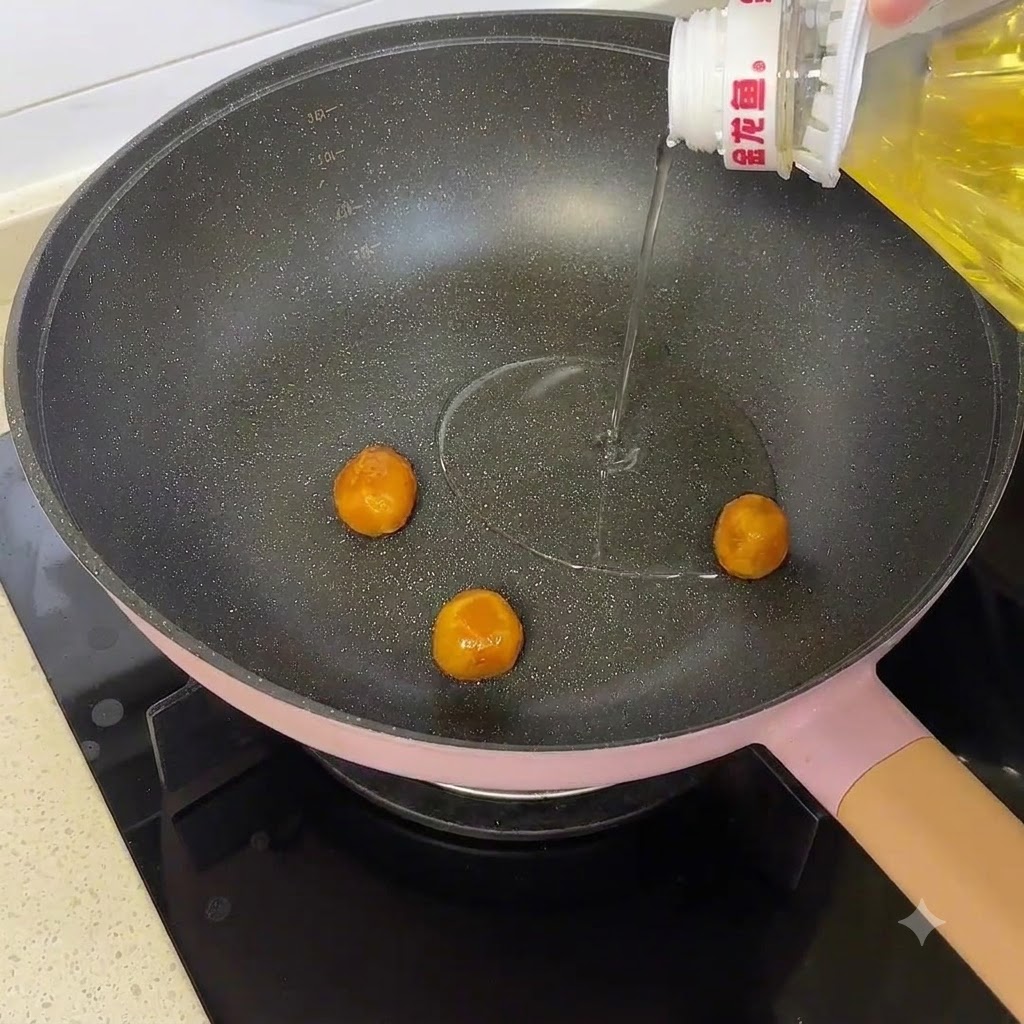 Des jaunes dœufs salés cuisant dans une poêle avec de lhuile de cuisson versée depuis une bouteille.