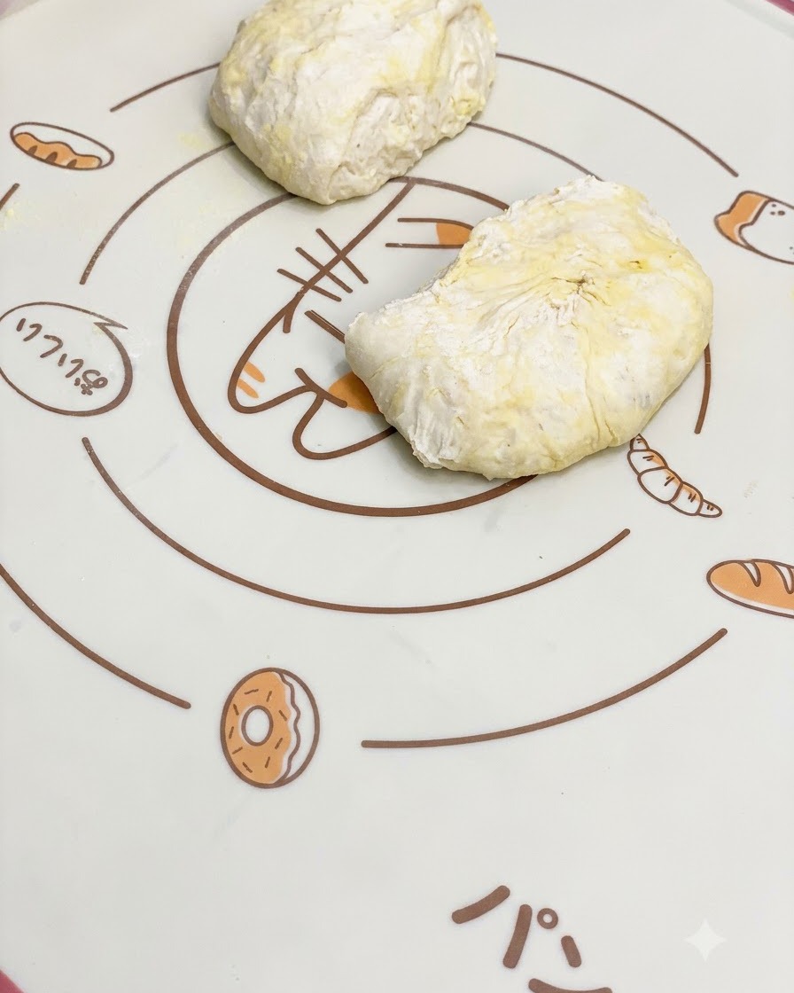 Des morceaux de pâte à pizza fermentée reposant sur un tapis de cuisson en silicone à motifs.
