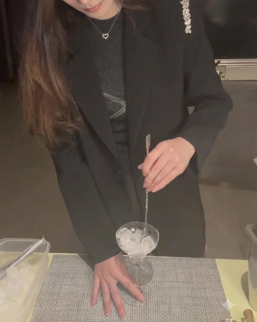 Des glaçons à lintérieur dun verre à martini remués avec une cuillère à cocktail pour le refroidir.