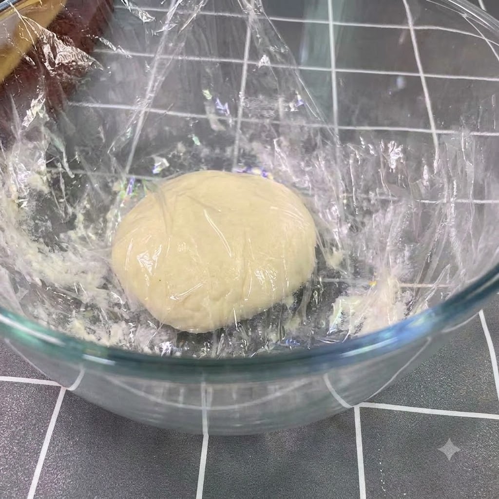 Pâte fermentée au repos et ayant doublé de volume dans un grand bol en verre.