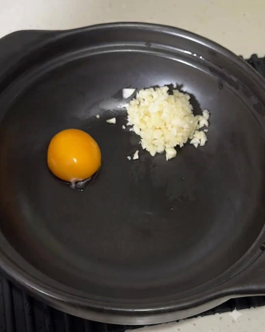 Poudre dassaisonnement pour nouilles instantanées versée dans la casserole à côté du jaune dœuf et de lail.