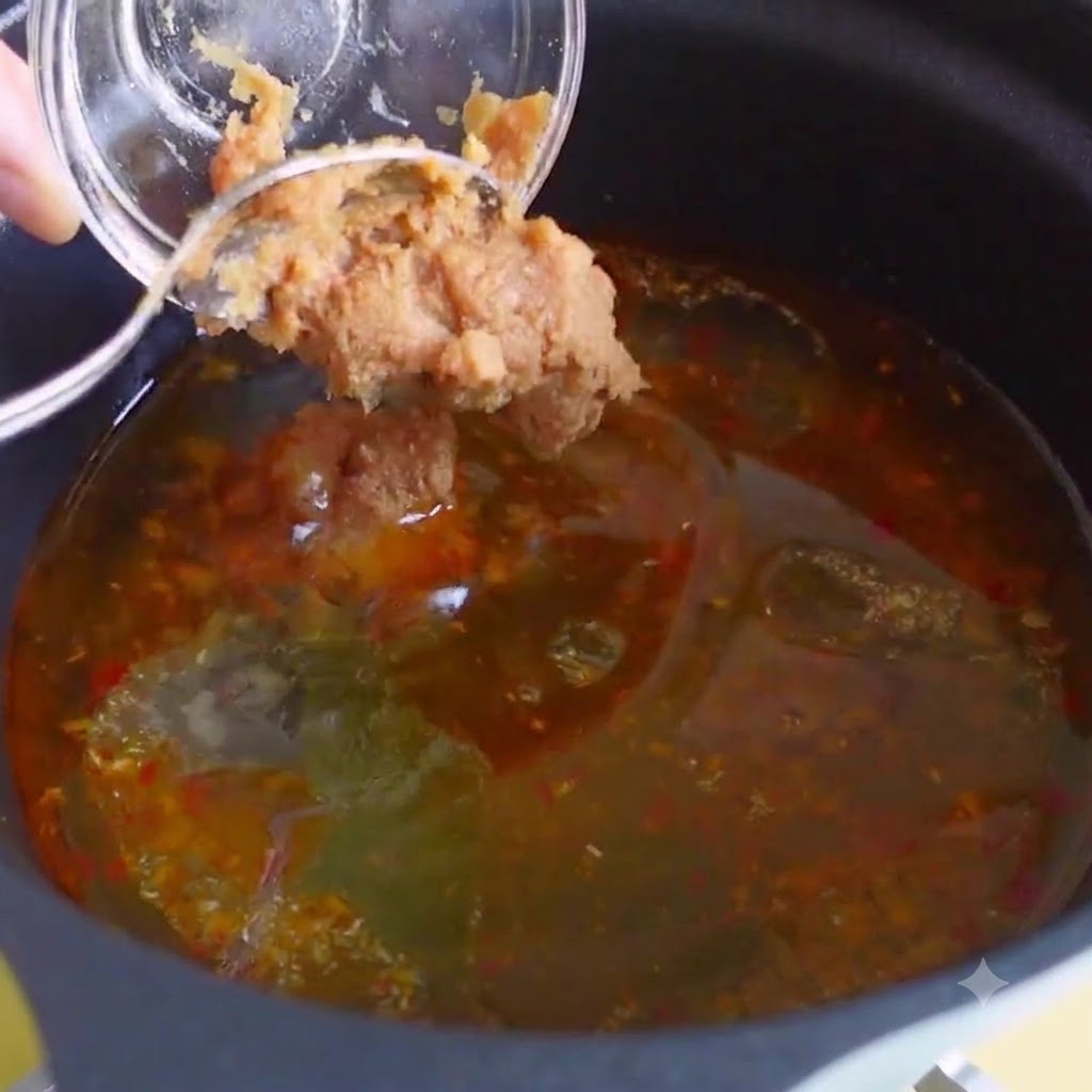 Du bouillon de poulet, de lextrait de bonite et de la pâte de piment coréenne mélangés dans le bouillon de soupe.