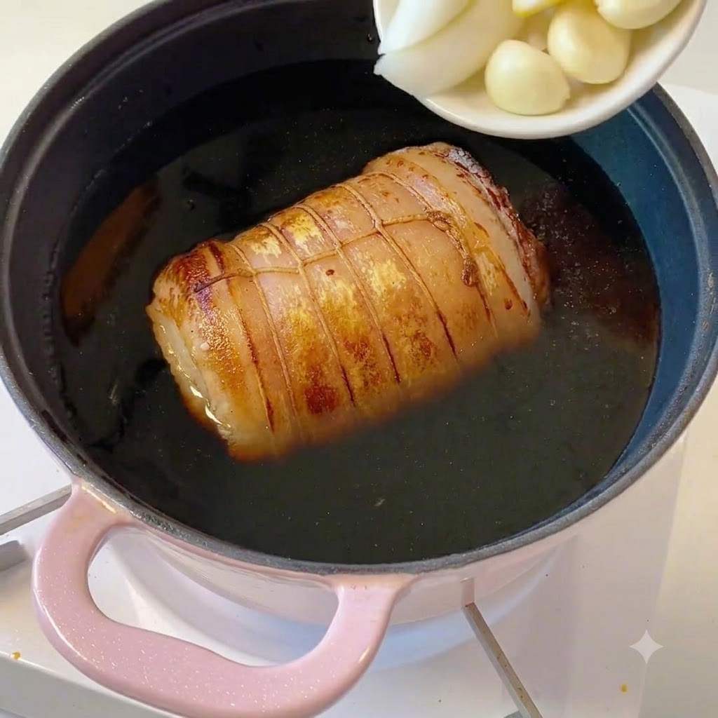 Un petit plat blanc contenant des tranches de cébettes, des morceaux de gingembre et des gousses dail versés dans la casserole.