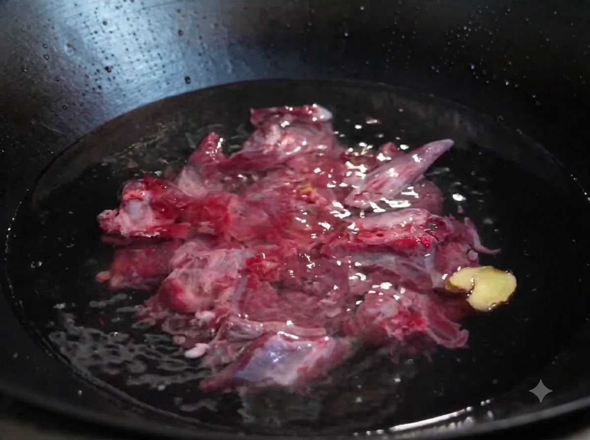 Côtes de bœuf crues immergées dans leau froide dans un wok avec des tranches de gingembre et un oignon vert.