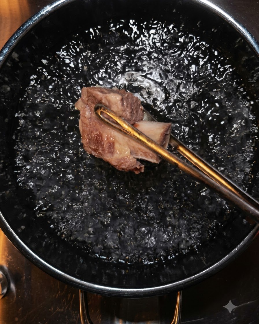 Des pinces soulevant un morceau de bœuf de leau bouillante.