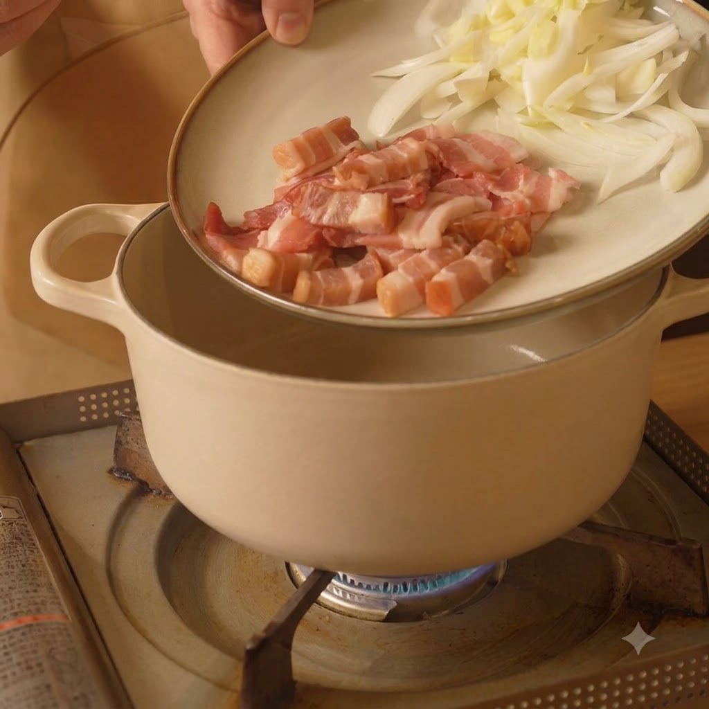Une assiette contenant du lard tranché et des oignons versée dans une casserole de cuisson blanche sur une cuisinière.