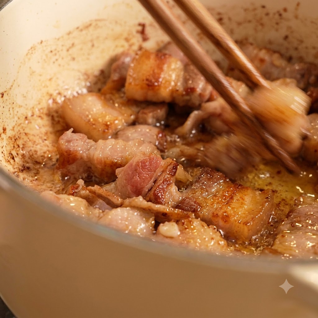 Des baguettes remuant des morceaux de viande dorés frits dans de lhuile à lintérieur dune casserole blanche.