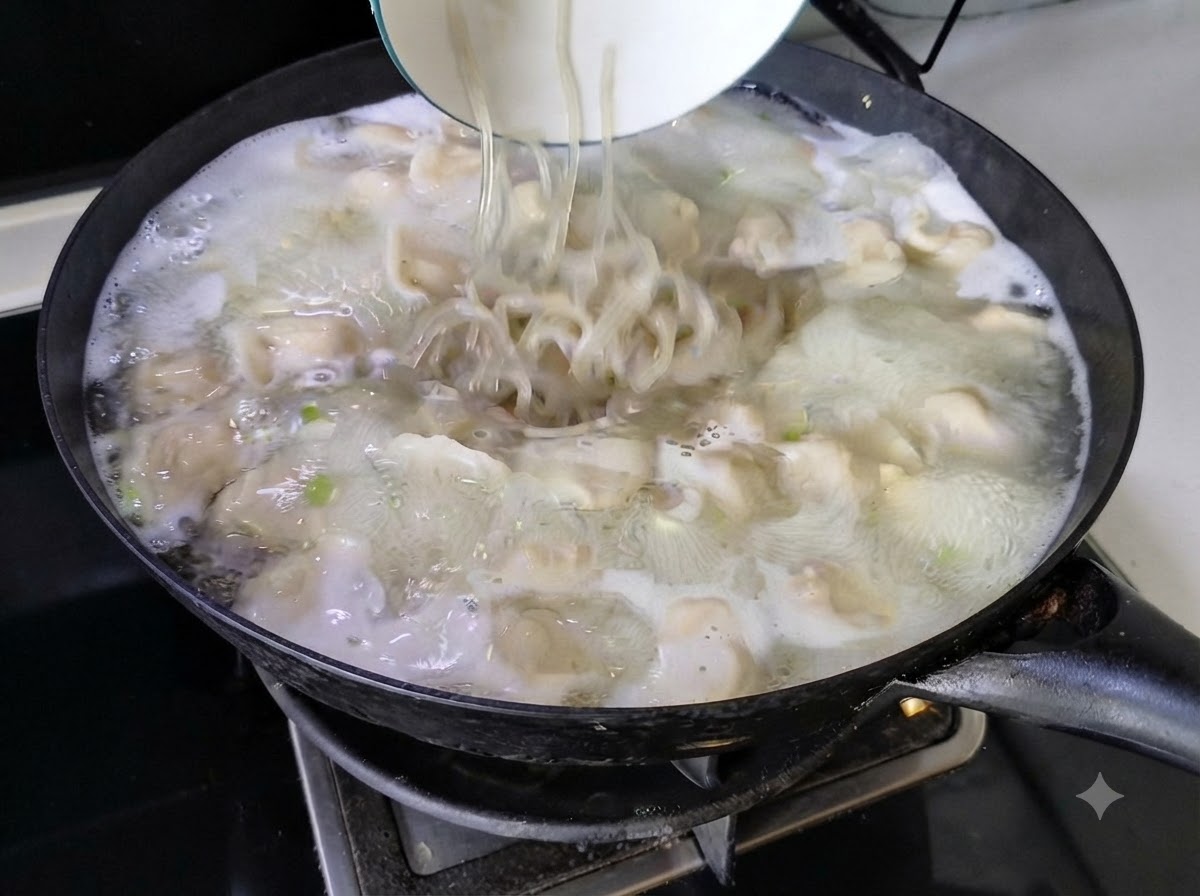 Des nouilles versées dun bol blanc dans la soupe de raviolis bouillante dun wok.