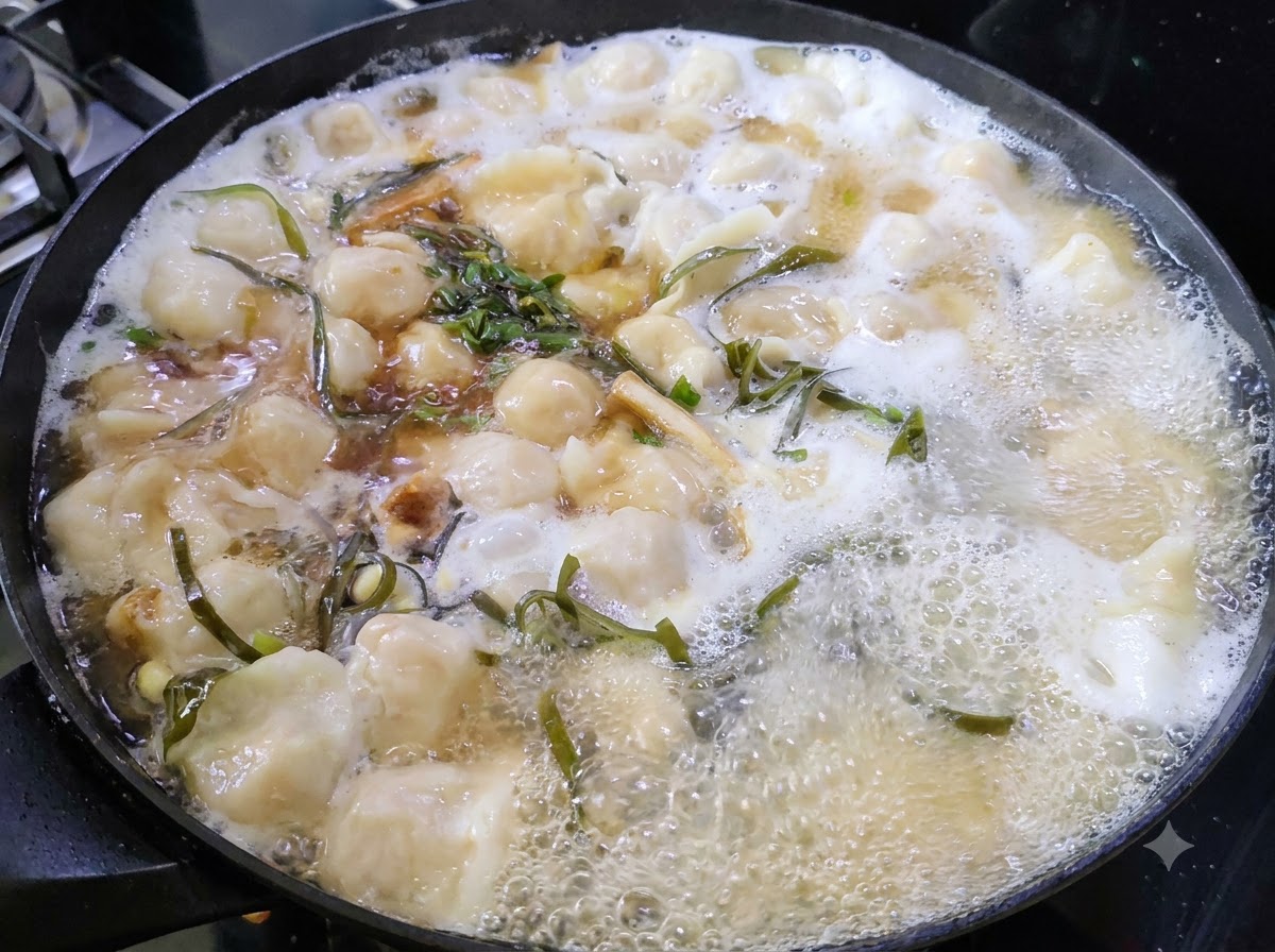 Des herbes vertes hachées flottant à la surface dune casserole de soupe de raviolis frémissante.