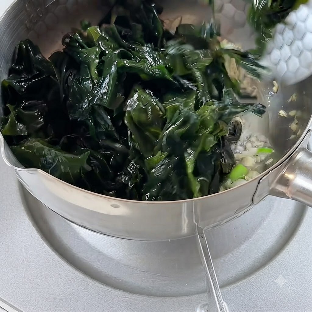 Algues réhydratées ajoutées dans la casserole contenant lail et les oignons frits.