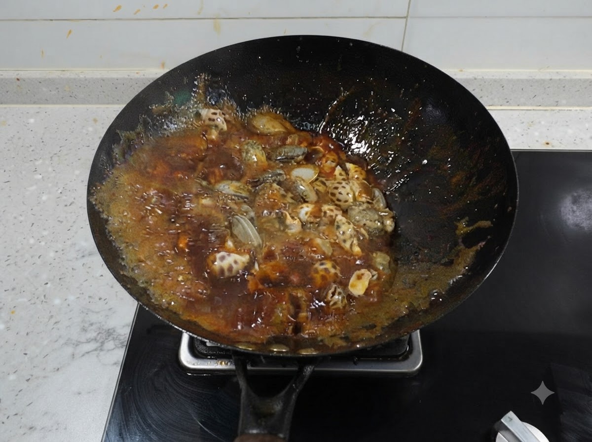 Escargots de mer et petits poulpes mijotant dans un bouillon rouge sombre et bouillonnant dans un wok noir.