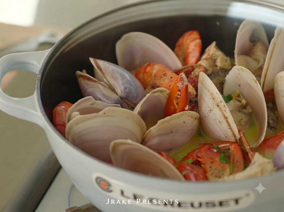Jus de citron frais en train dêtre pressé sur la cocotte de fruits de mer cuits.