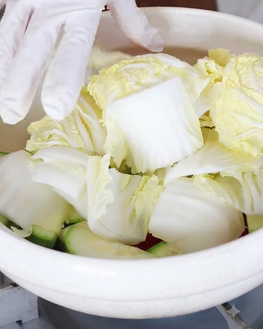 Des morceaux de mini-chou ajoutés sur les légumes dans la marmite.