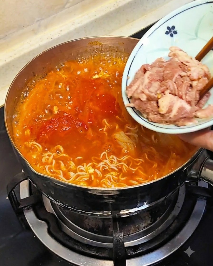 Des baguettes immergeant de la viande crue coupée finement depuis une petite assiette dans le bouillon chaud.