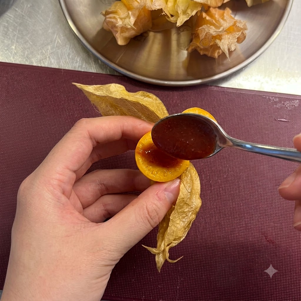 Une petite cuillère ajoutant une cuillerée de sauce chili rouge au centre dune groseille à maquereau tranchée.