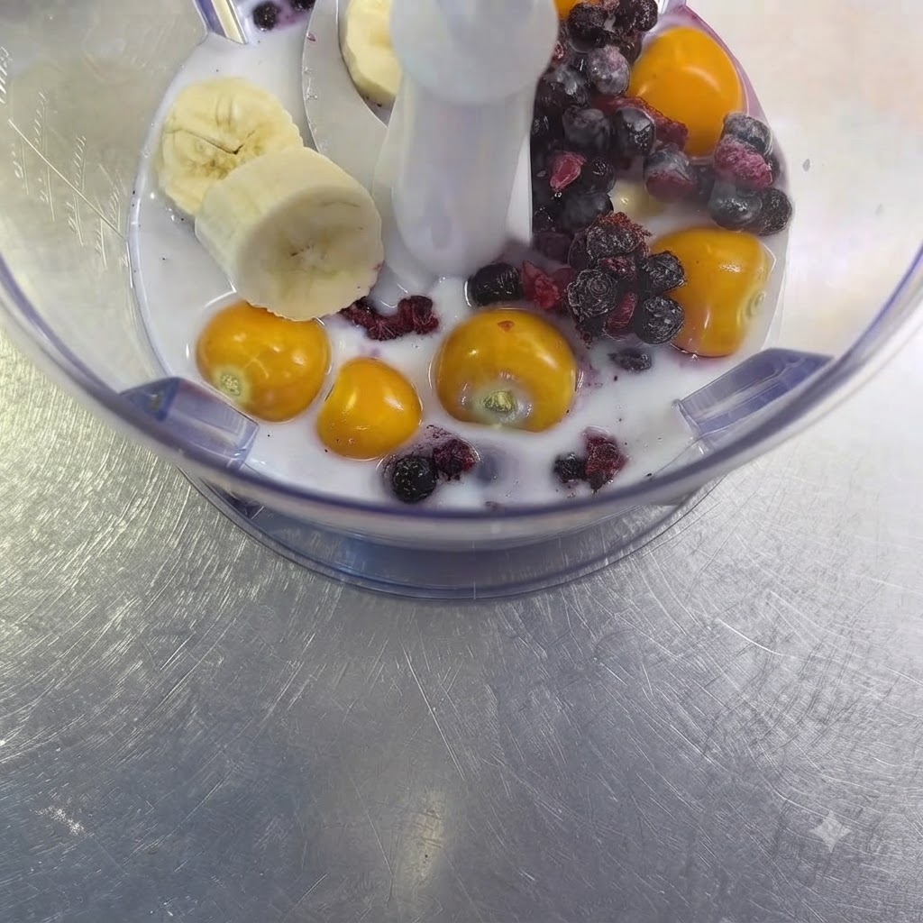 Une gousse dail cru reposant parmi le mélange de fruits et de lait à lintérieur du gobelet du mixeur.