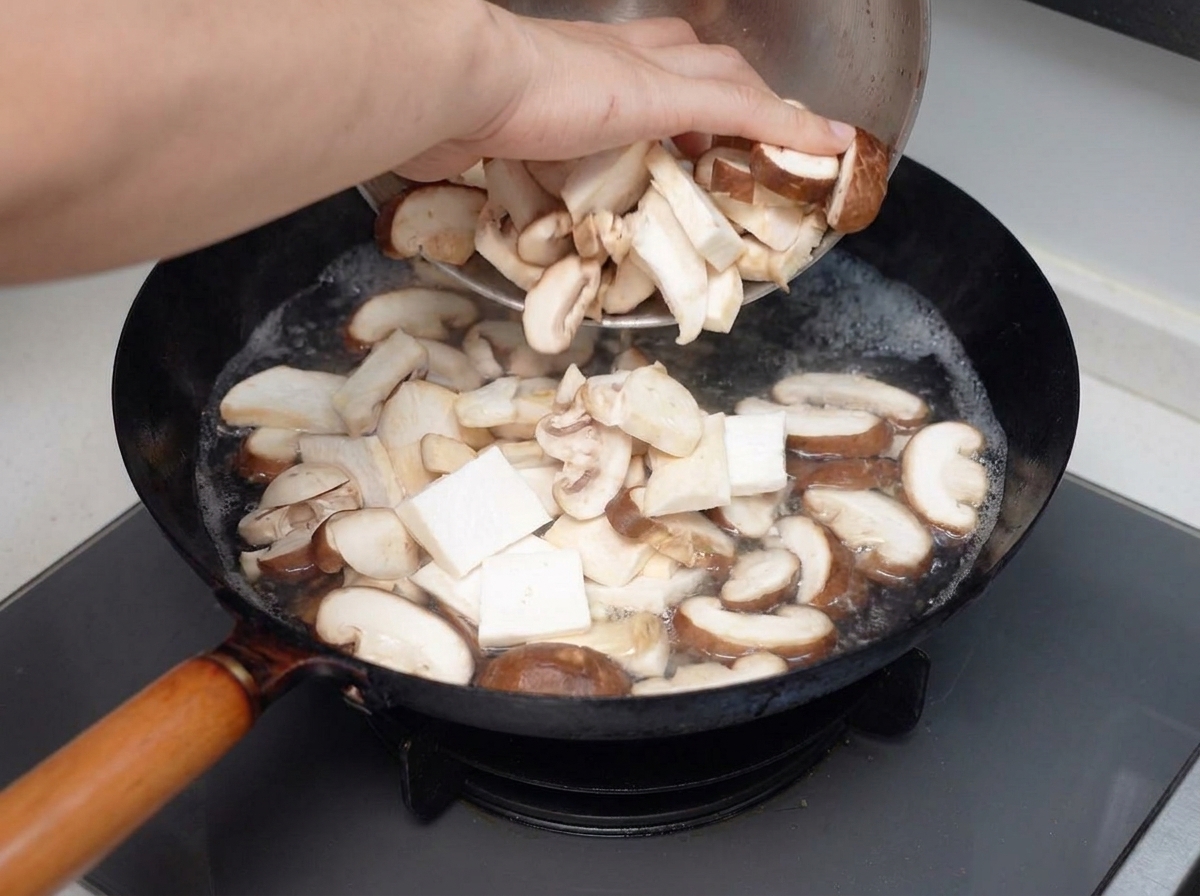 Des champignons mélangés tranchés versés dans une casserole deau bouillante.