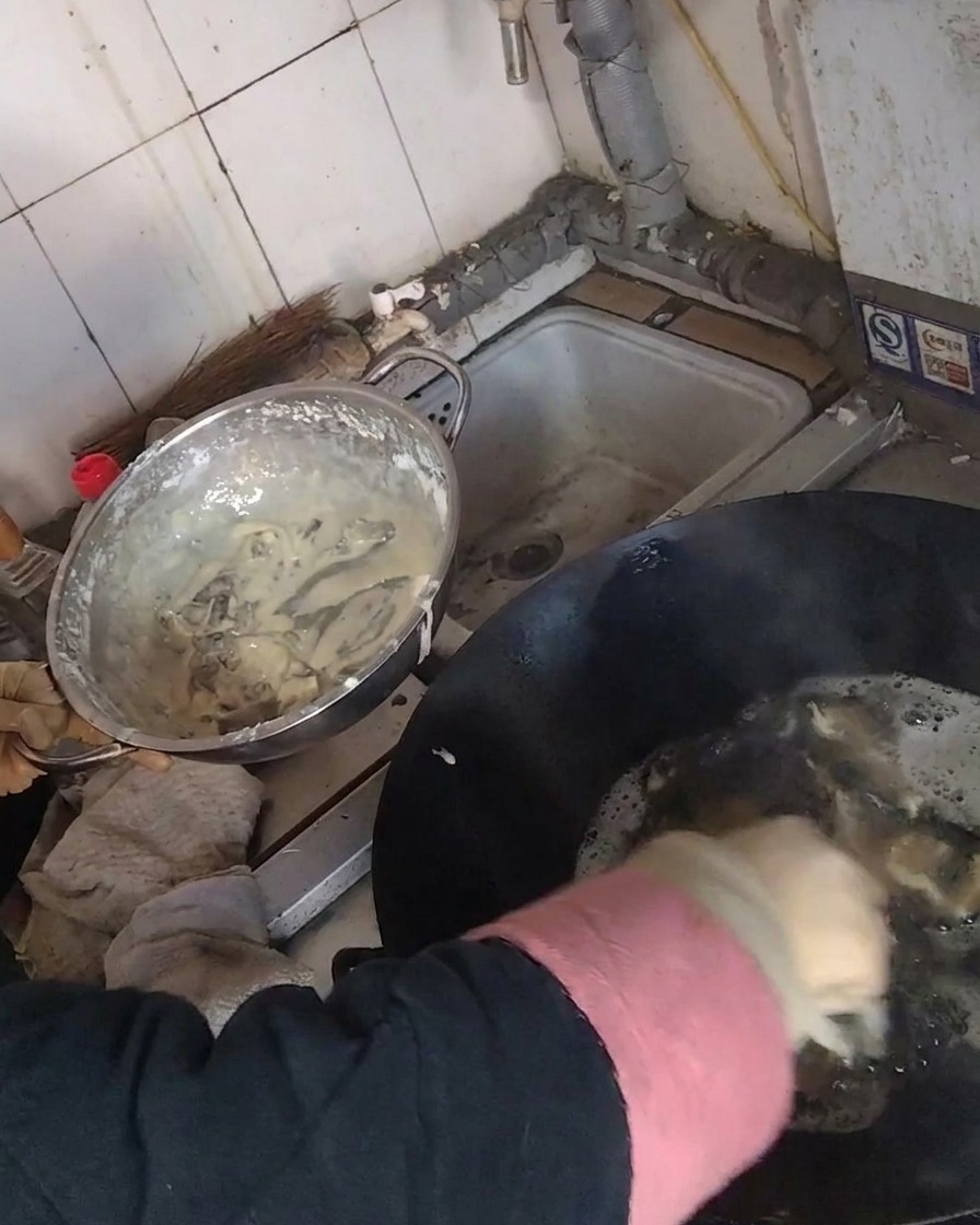 Friture de lanières de champignons enrobées dans un wok rempli dhuile chaude.
