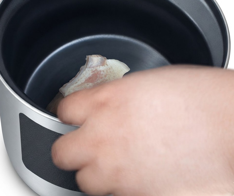 Morceaux de porc blanchi placés avec précaution dans un pot en argile.