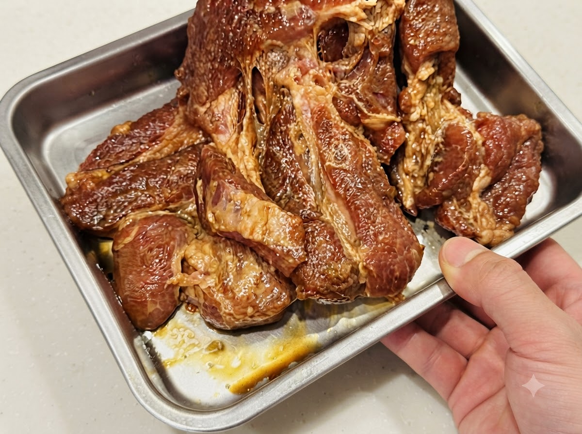 Côtes de porc disposées à plat en une seule couche sur une plaque de cuisson recouverte de papier aluminium.