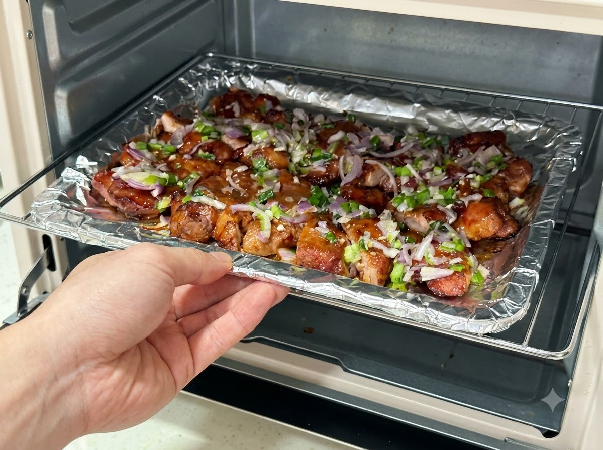 Plaque de cuisson garnie de morceaux de porc nappés de sauce réintroduite dans une friteuse sans huile.