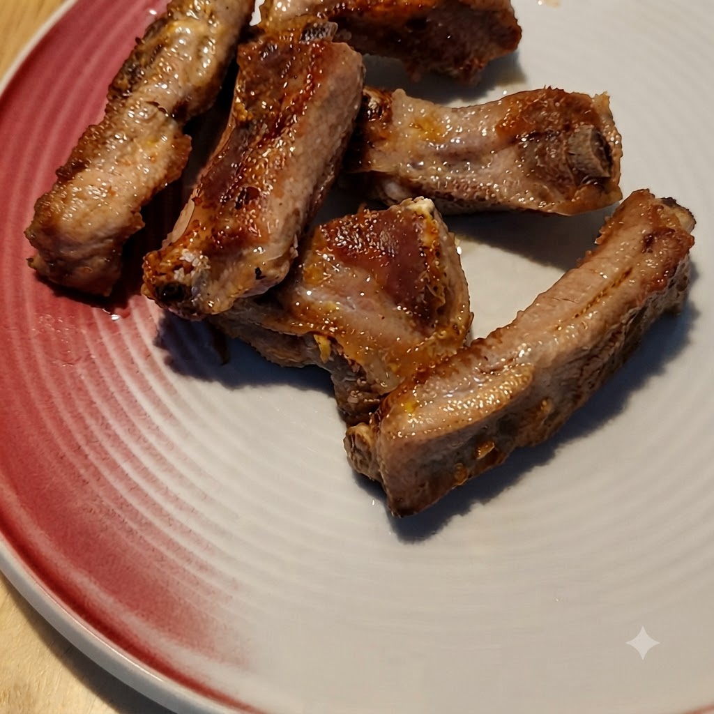 De la sauce au café versée sur des travers de porc dorés dans une poêle.