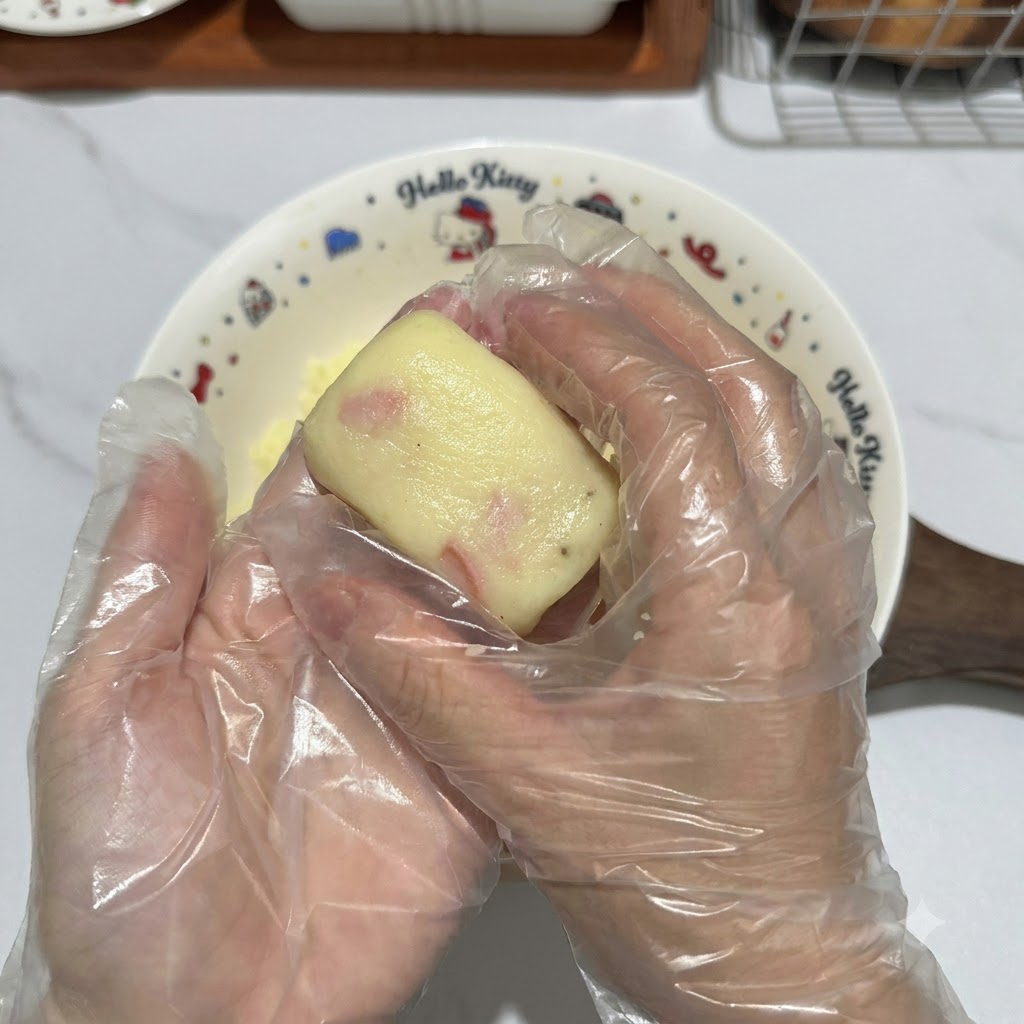 Mains gantées façonnant un morceau de pâte de pommes de terre en une jolie galette rectangulaire.