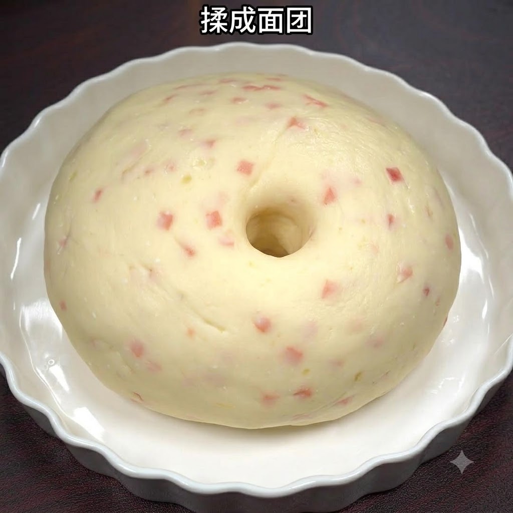 Pâte lisse à base de pommes de terre et de jambon façonnée en boule dans un plat en céramique blanche.